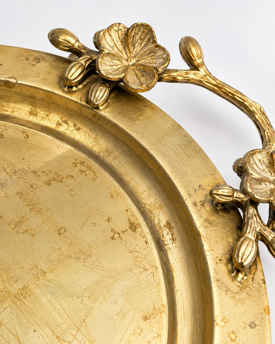 Detalle del asa de flores y del metal manchado de la bandeja Doña Matilde