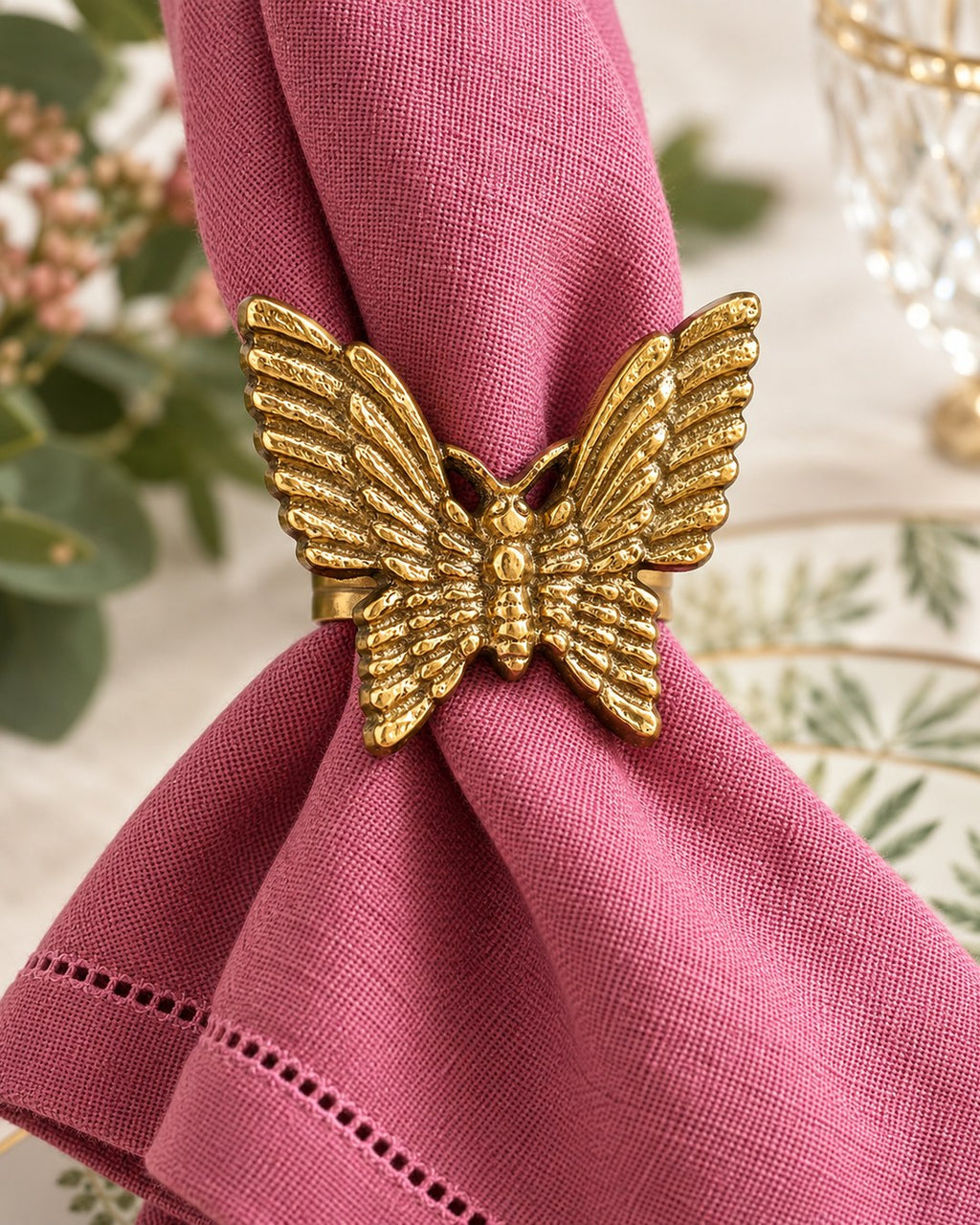 Servilletero Mariposa con servilleta de lino rosa en una mesa puesta
